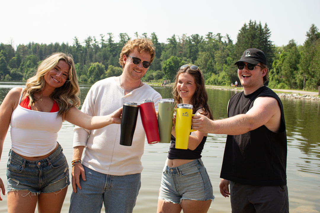 Group of friends enjoying Chilly Moose tumblers by the lake on a sunny summer day