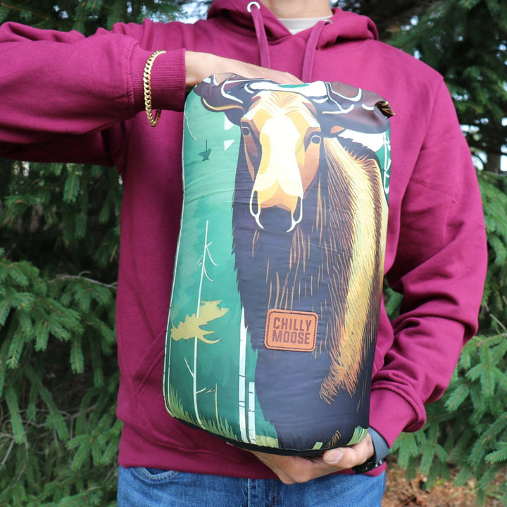 Forest Guardian Ultralight Blanket – Chilly Moose – Packed in stuff sack held outdoors #colour_forest