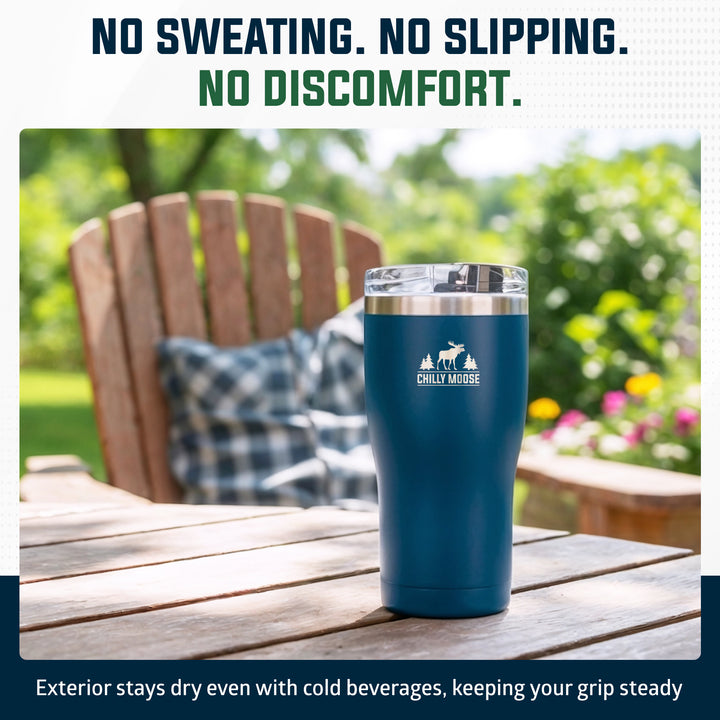 A dark teal insulated tumbler with a silver rim and a white Chilly Moose logo, standing on a wooden table in an outdoor garden setting. Text at the top reads 'NO SWEATING.#colour_navy