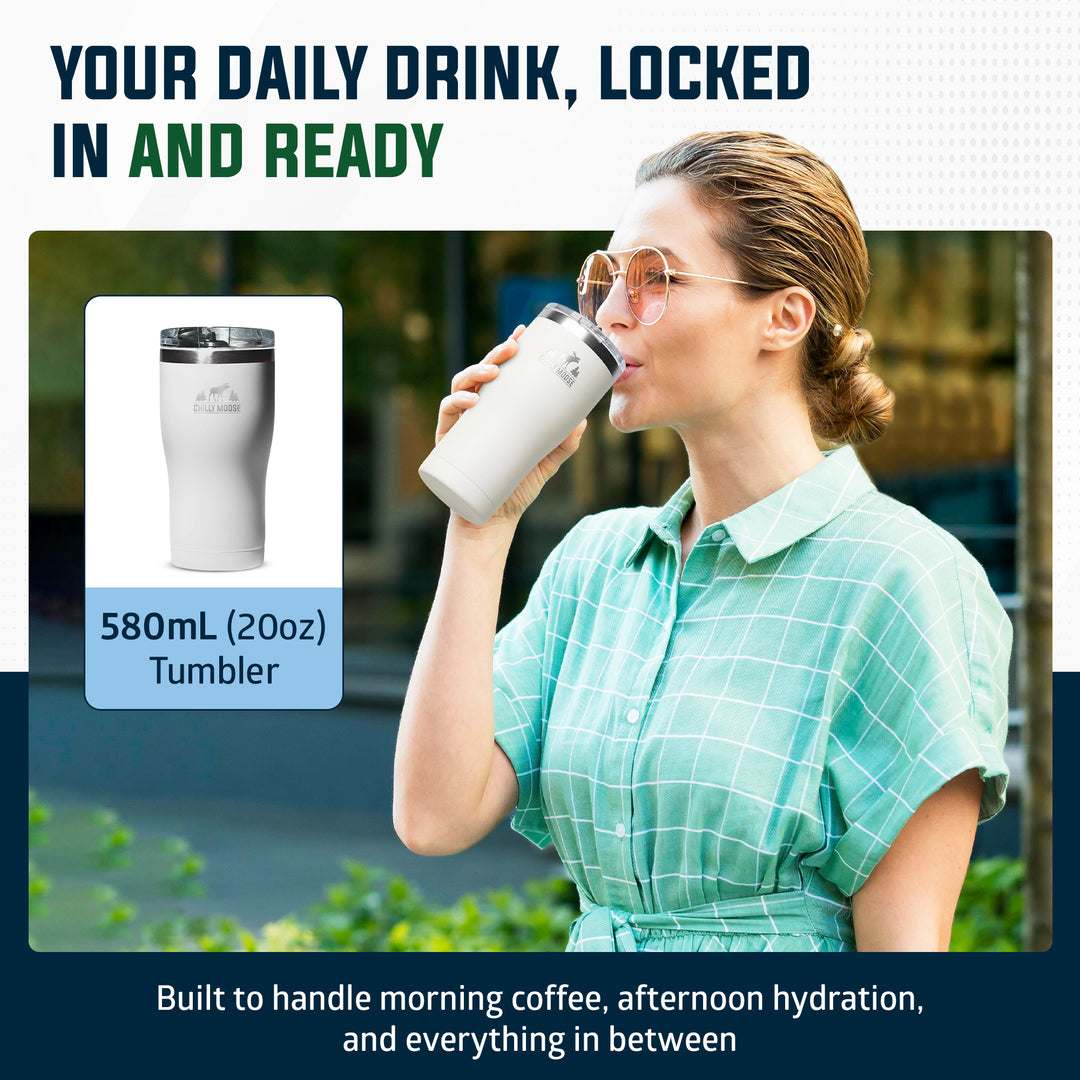 A woman in a mint green plaid shirt drinks from a white insulated tumbler with a dark lid. The image includes a product inset showing the tumbler alone and marketing text that reads 'YOUR DAILY DRINK, LOCKED IN AND READY' and '580mL (20oz) Tumbler. #colour_frost-white