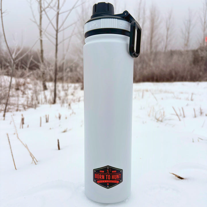 Clear water bottle with black cap and 'Born to Hunt' logo in a snowy landscape #colour_frost-white