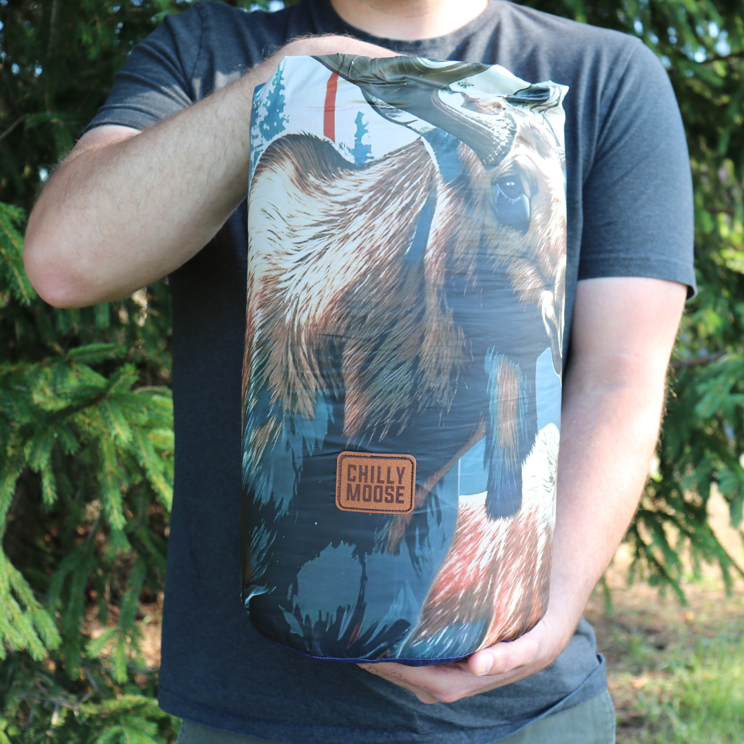 Oh Canada Ultralight Puffy Blanket – Chilly Moose – Rolled in stuff sack outdoors #colour_oh-canada