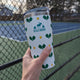 20oz Pickleball Tumbler – Chilly Moose – Hand holding white tumbler with pickleball paddle pattern at court #colour_white