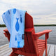 Sandbanks Quick Dry Travel Towel – Chilly Moose – Draped on red chair by lake #style_current-club-quick-dry-travel-towel