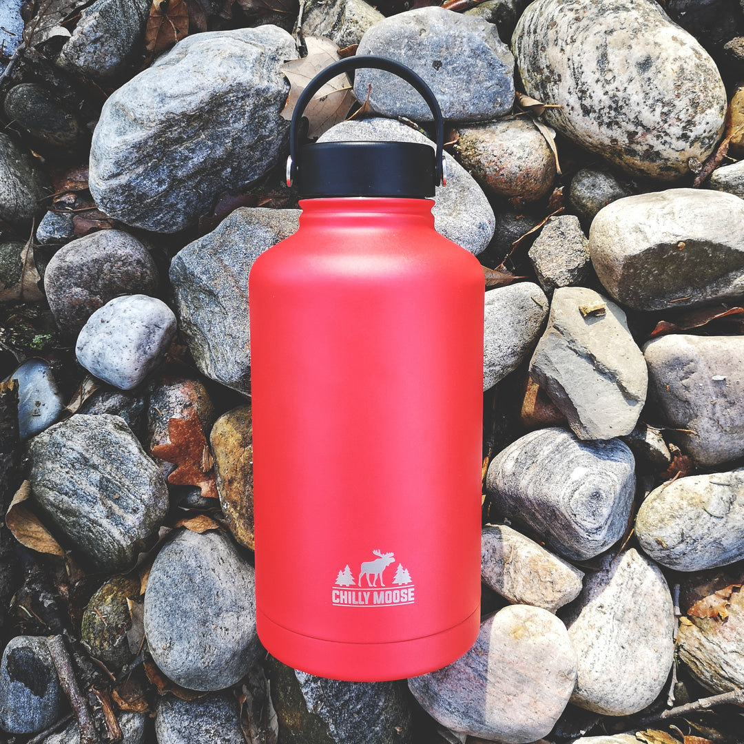 Portage Growler 64oz in Canoe Red – Chilly Moose – Lifestyle on Rocks #colour_canoe-red